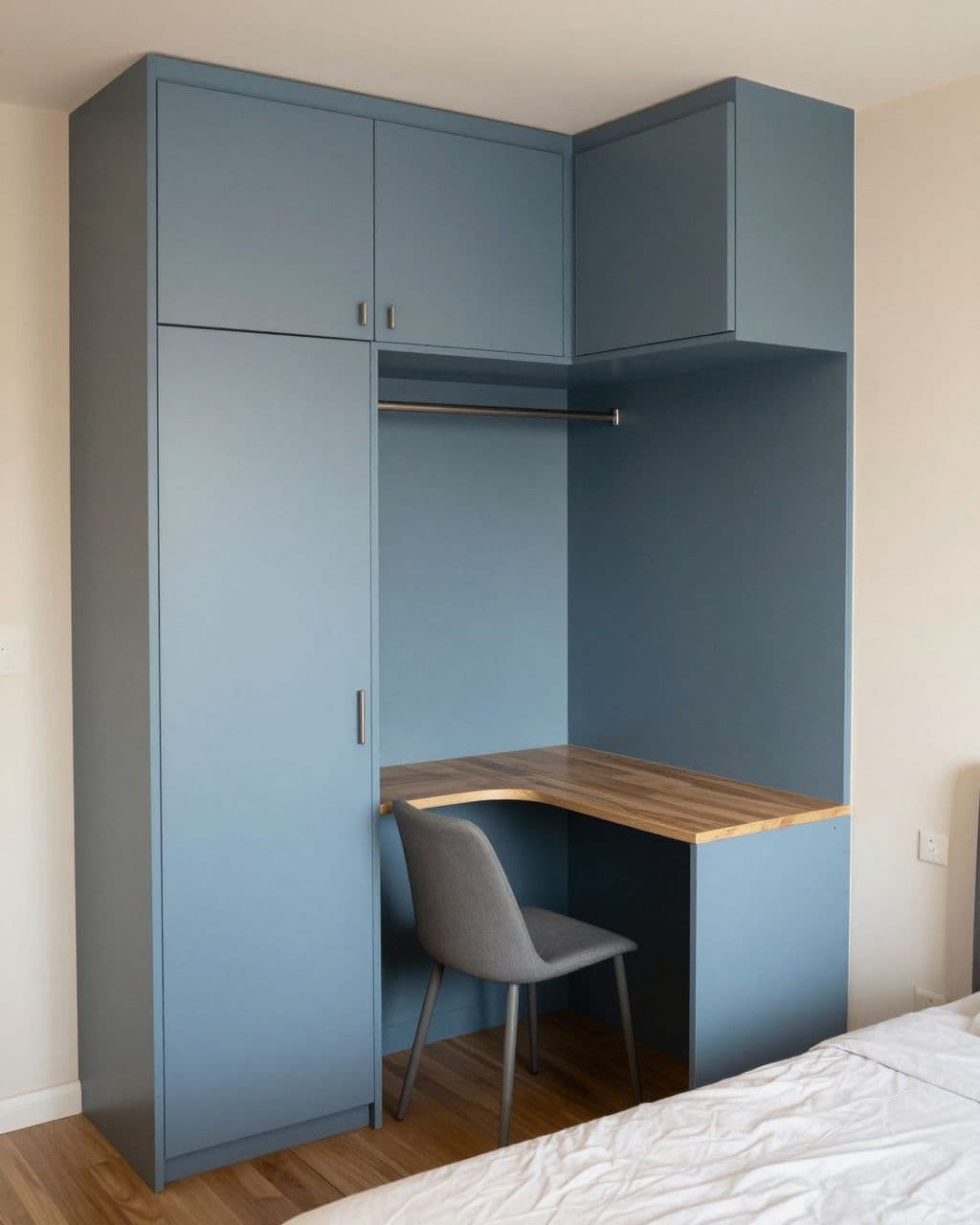 Small bedroom with blue storage, a fold-down desk, compact bed, and slim chair.