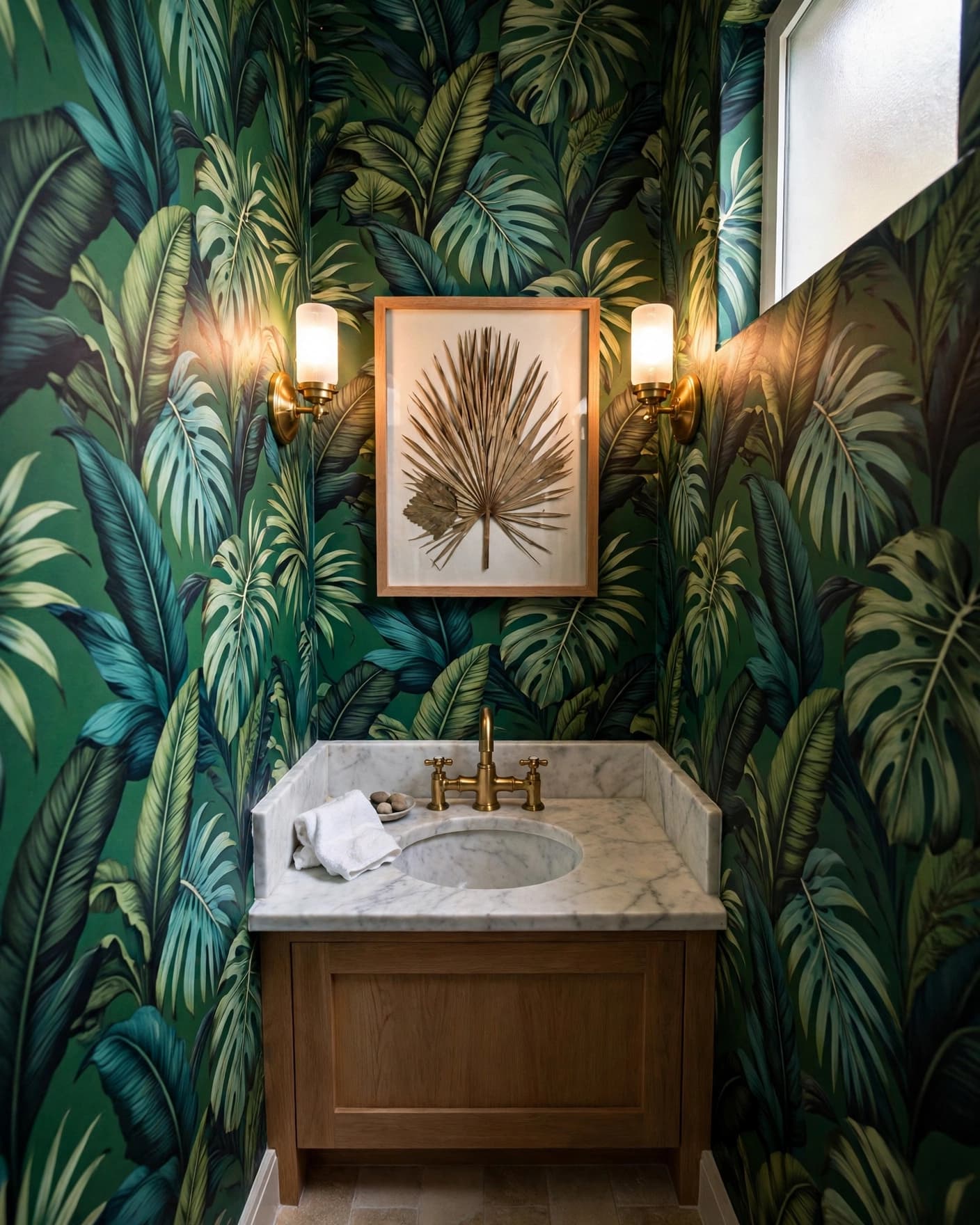 Narrow powder room with tropical wallpaper, a marble sink, and framed palm leaf art.